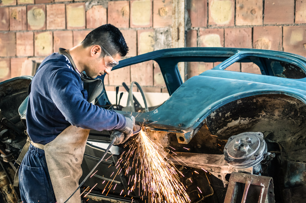 Young,Man,Mechanical,Worker,Repairing,An,Old,Vintage,Car,Body