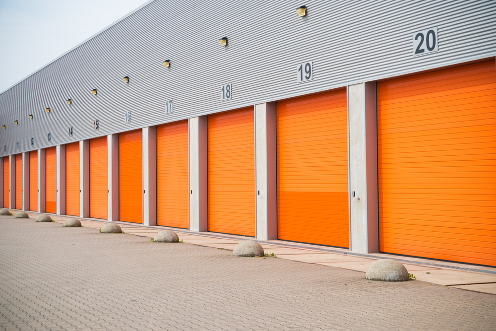 Exterior,Of,A,Commercial,Warehouse,With,Orange,Roller,Doors